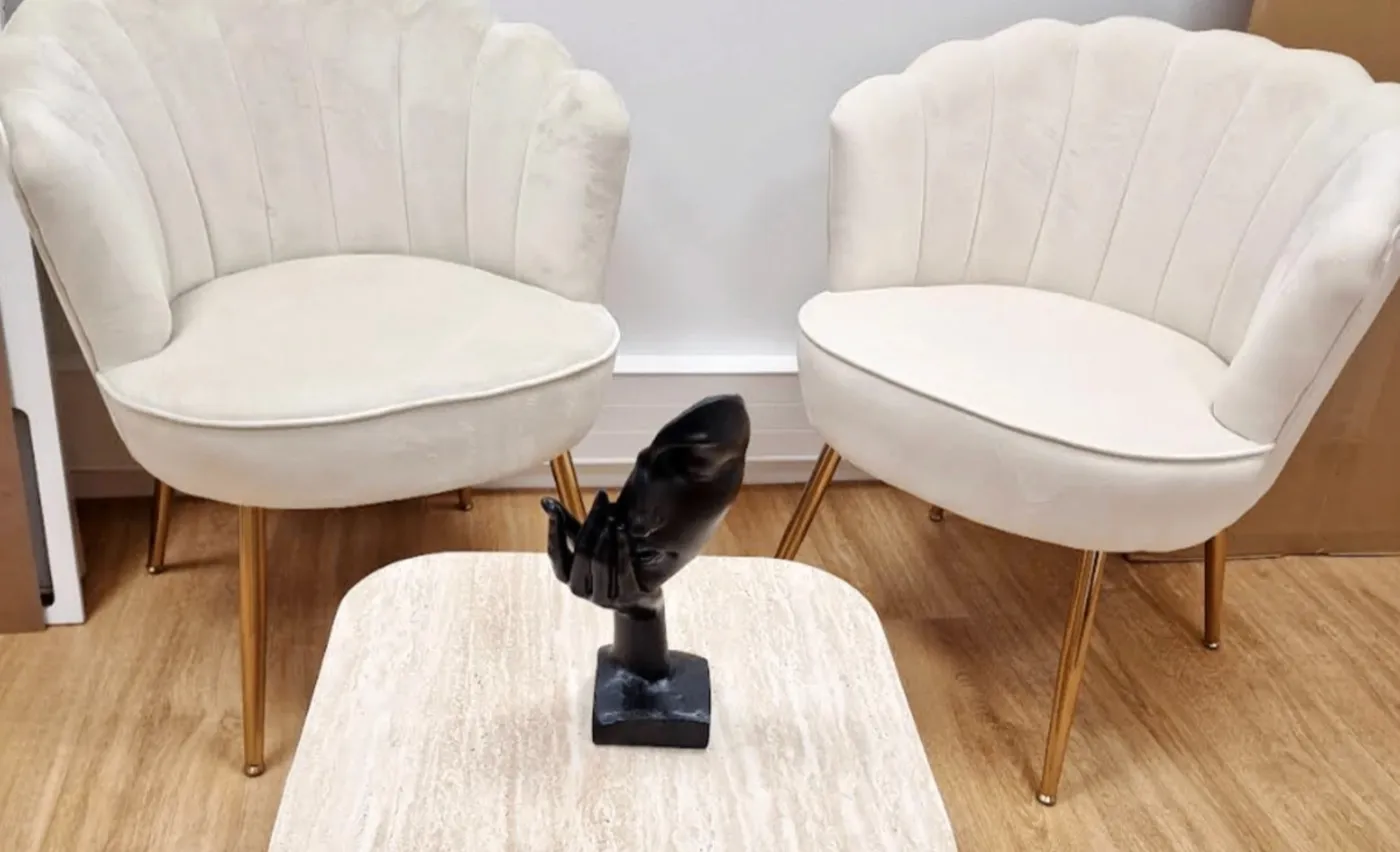 L’espace d’accueil de l’institut à Chessy : deux fauteuils en velours ivoire et une table en travertin